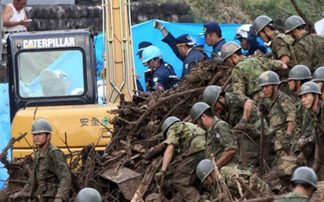 Японські солдати розбирають завали будинків, які були зруйновані під час повені, у Яоцу. В наслідок повені, яка була викликана тропічними зливами, 6 людей вважаються зниклими без вісти. / © AFP