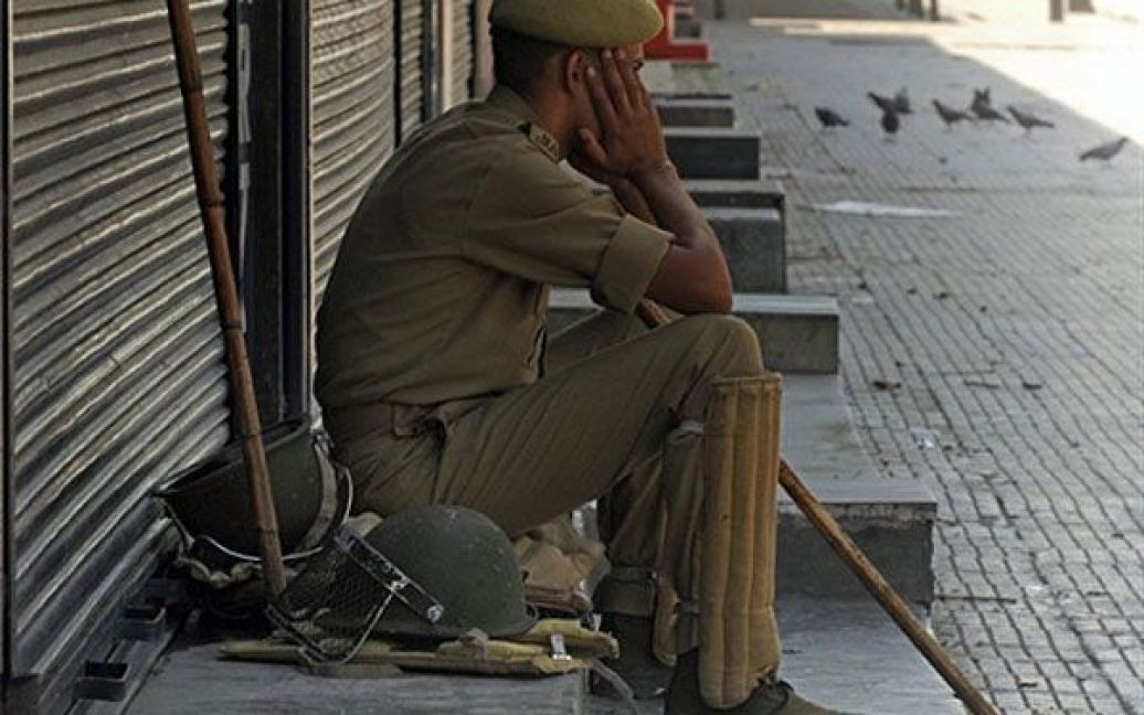 Індія, Срінагар. Втомлений поліцейський сидить на пустій вулиці міста Срінагар. Головний міністр індійського штату Кашмір взяв участь у кризових переговорах у Нью-Делі щодо спалаху насильства між антиіндійськими протестувальниками і поліцейськими. В результаті зіткнень загинуло більше 30 людей. Індійським штатом Кашмір прокотилася хвиля заворушень, які стали найжорстокішими за останні два роки у цьому регіоні з переважно мусульманським населенням. / © AFP