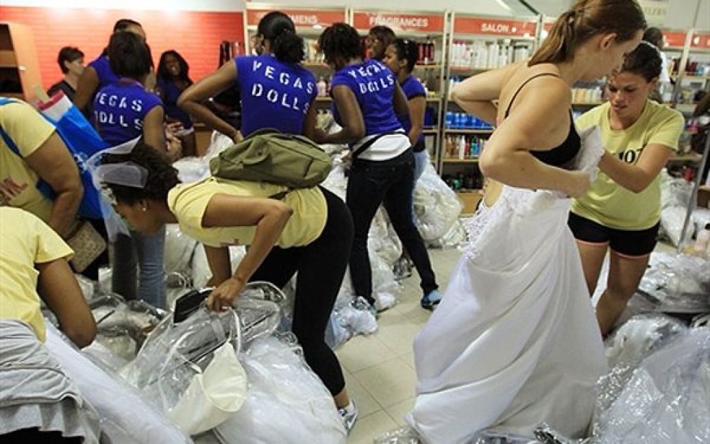 Дівчата міряють весільні сукні під час одноденного розпродажу у магазині Filene&#039;s у Меріленді. Кожного року тисячі наречених чекають 30 липня, щоб купити собі сукню із значною знижкою. / © AFP
