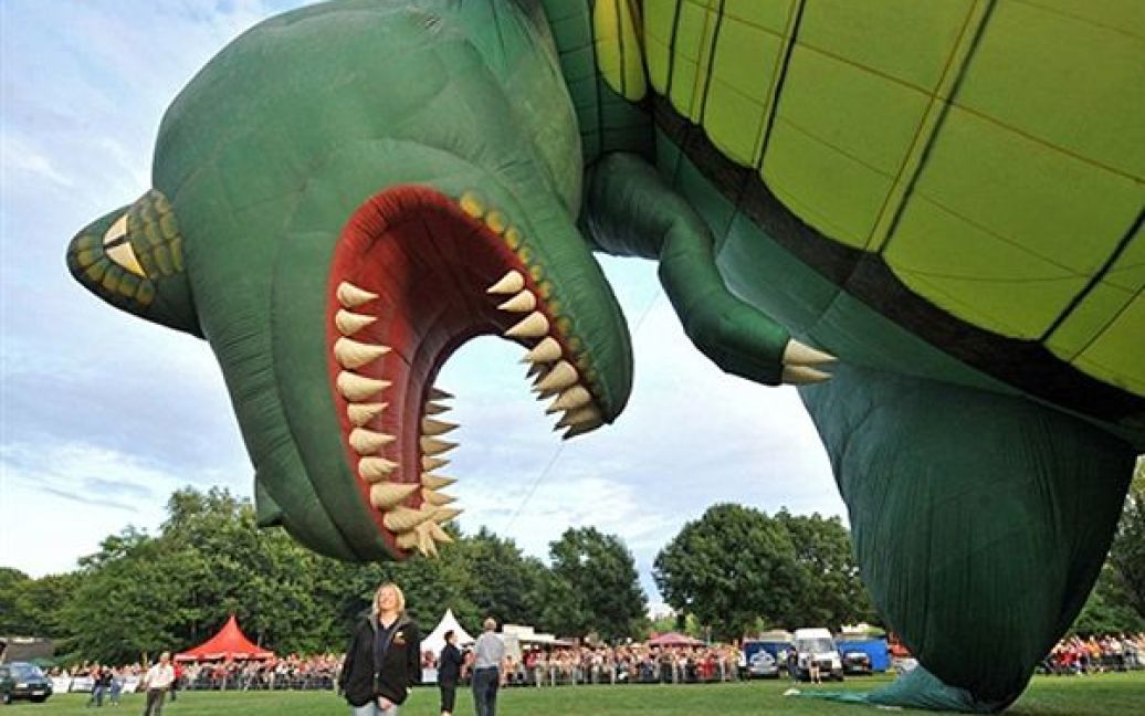 Лейпциг. Учасники Саксонського фестивалю повітряних куль надувають кулю у вигляді величезного динозавра. Фестиваль закінчиться 1 серпня. / © AFP