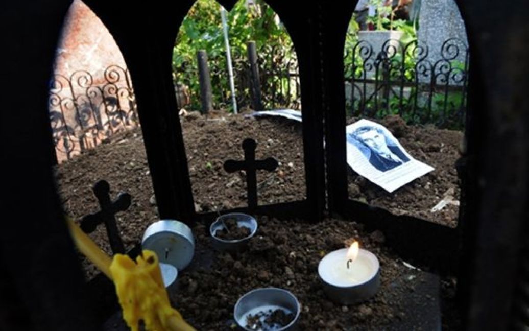 Фотографія диктатора Ніколае Чаушеску лежить на його могилі на кладовищі у Бухаресті. Нещодавно тіла Чаушеску та його дружини були ексгумовані для ДНК-тесту, який мав розкрити таємницю падіння комуністичного режиму у Румунії. Після тесту тіла були перепоховані. / © AFP