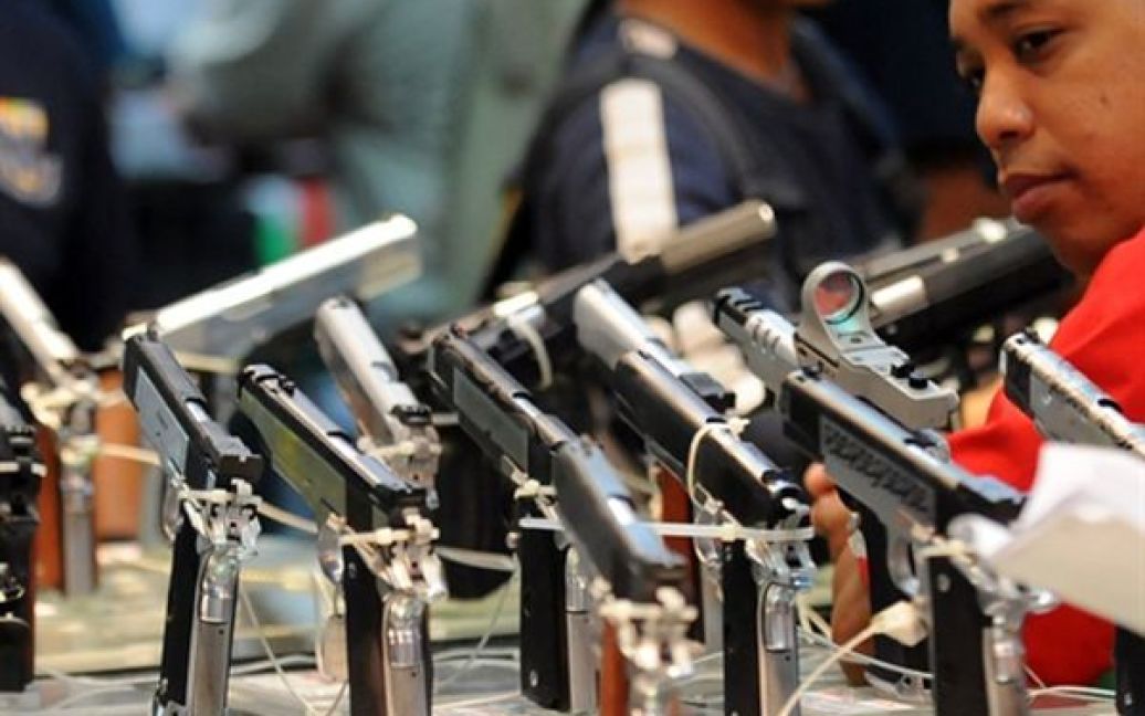 Чоловік розглядає пістолети 45-го калібру під час розпродажу конфіскованої зброї, який влаштувала філіппінська поліція. З 90 мільйонів людей населення Філіппін дозвіл на носіння зброї мають 1,8 мільйонів людей та ще 1,2 тримають її незаконно. / © AFP