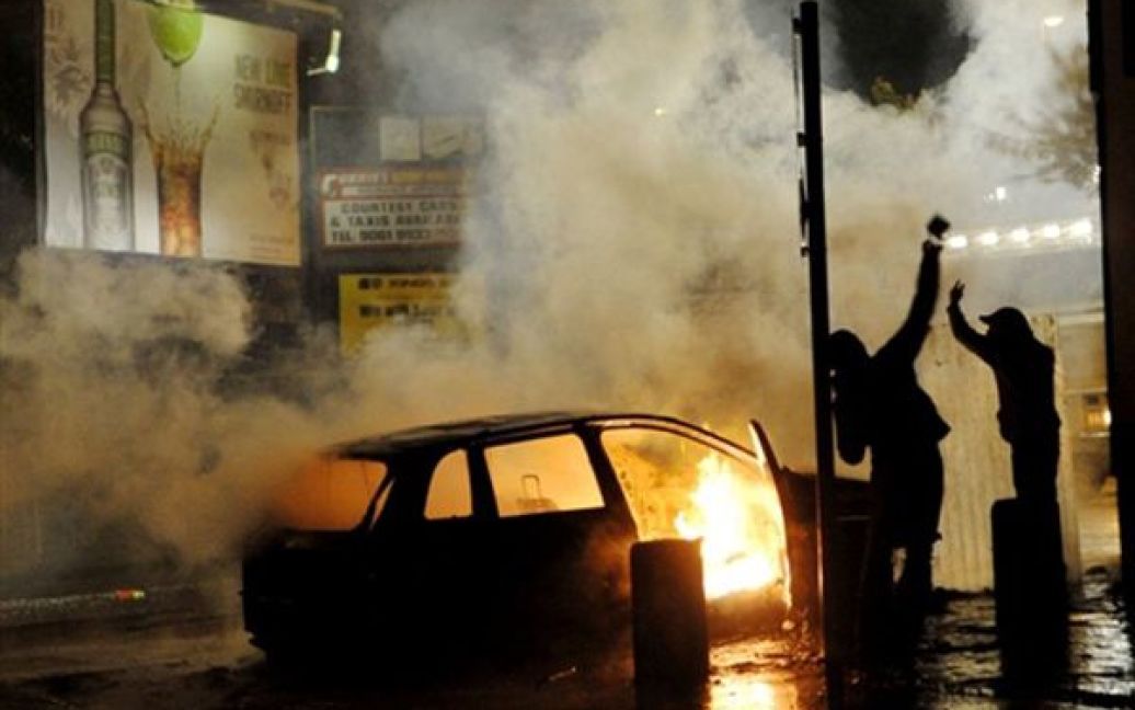 Демонстранти підпалили машину на одній з вулиці Белфасту. Заворушення націоналістів розпочалися у ніч перед парадом оранжистів, та тривають вже четвертий день. / © AFP