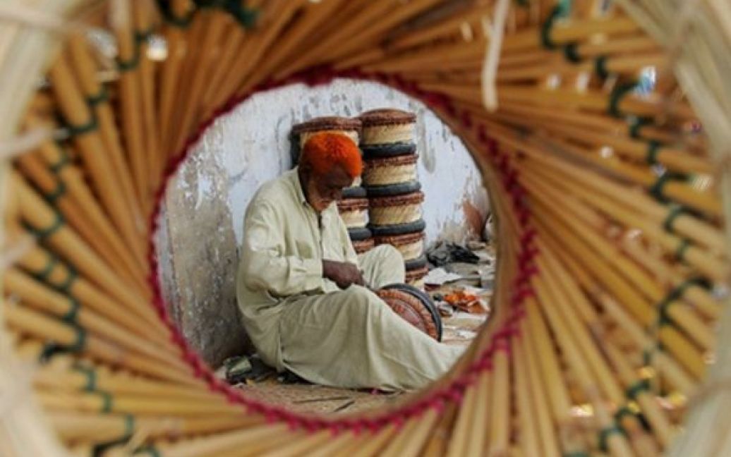 Ремісник займається виготовленням табуретів з соломи у Карачі. Пакистан попросив світову спільноту допомогти відбудувати економіку країни, яка була зруйнована війною. / © AFP
