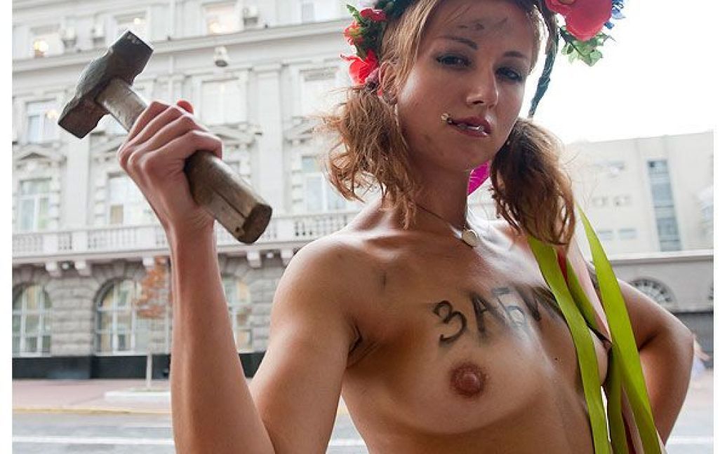 Активістка жіночого руху FEMEN з написом на грудях "Забили" вийшла до будівлі СБУ топлес, з молотком в руці та із цвяхами у роті. / © Жіночий рух FEMEN