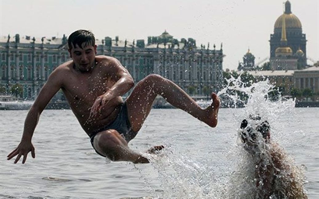 Росія, Санкт-Петербург. Чоловік купається у Неві в центрі Санкт-Петербурга, щоб охолонути від палючого літнього сонця. Температура у місті становить майже 33 градуси за Цельсієм. / © AFP