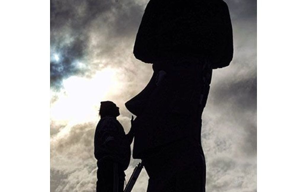 Чилі, острів Пасхи. Працівник відновлює і ремонтує Моаї &mdash; одну з кам&#039;яних статуй культури Рапа-Нуї на острові Пасхи, у 3700 км від чилійського узбережжя у Тихому океані. Сотні вчених, туристів і місцевих жителів зібрались на острові Пасхи, щоб побачити майже 5-хвилинне повне сонячне затемнення, яке відбулося 11 липня. / © AFP