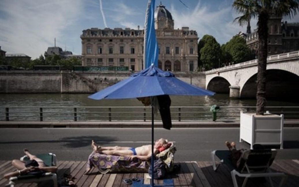 Люди відпочивають на "Паризькому пляжі". Вже дев&rsquo;яте літо поспіль набережна Сени перетворюється на повноцінний пляж із піском та пальмами. Закриється "Паризький пляж" 20 серпня. / © AFP