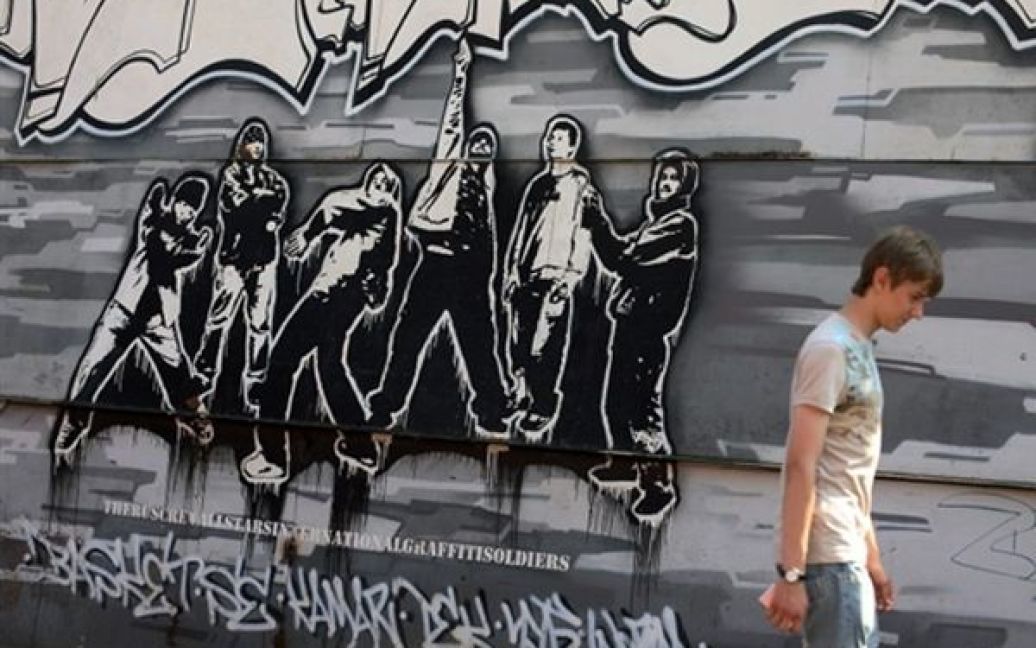 Чоловік проходить повз стіну, яку московська влада дозволила розмалювати вуличним художникам. / © AFP