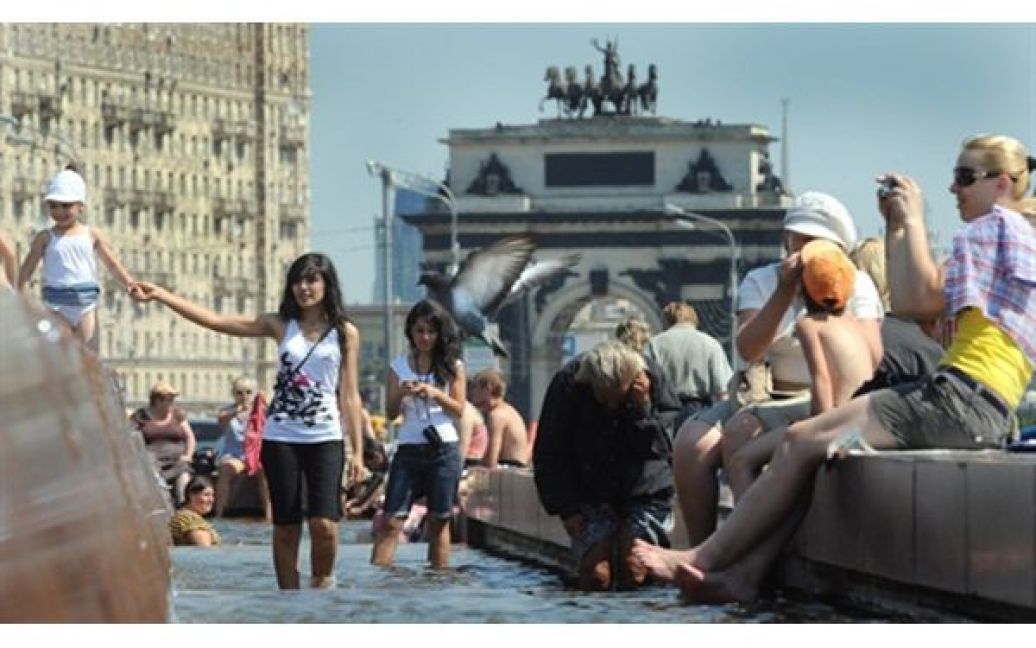 Люди купаються у фонтані на Манежній площі у Москві. Температура повітря у російській столиці сягнула 38 градусів. / © AFP