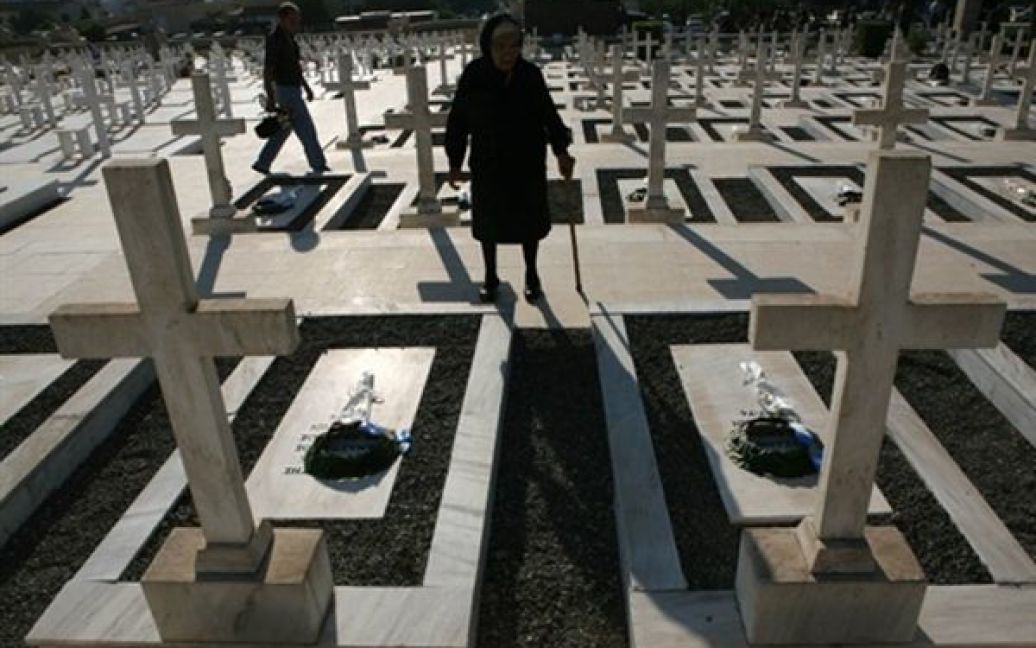 Жінка покладає квіти до могили грецьких солдатів, які загинули під час турецького вторгнення на Кіпр 1974 року на кладовищі у Нікосії у день 36-ої річниці конфлікту. / © AFP