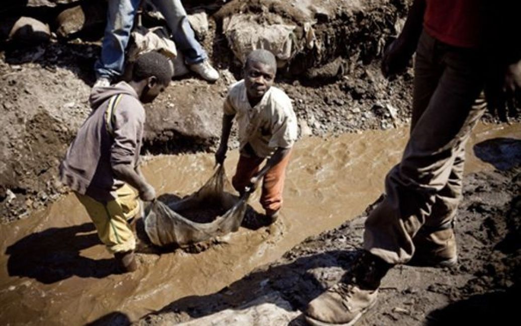 Діти миють мідну руду на копальнях у Конго. Більшість дітей у Конго кидають навчання, щоб допомагати своїм батькам утримувати родину. / © AFP