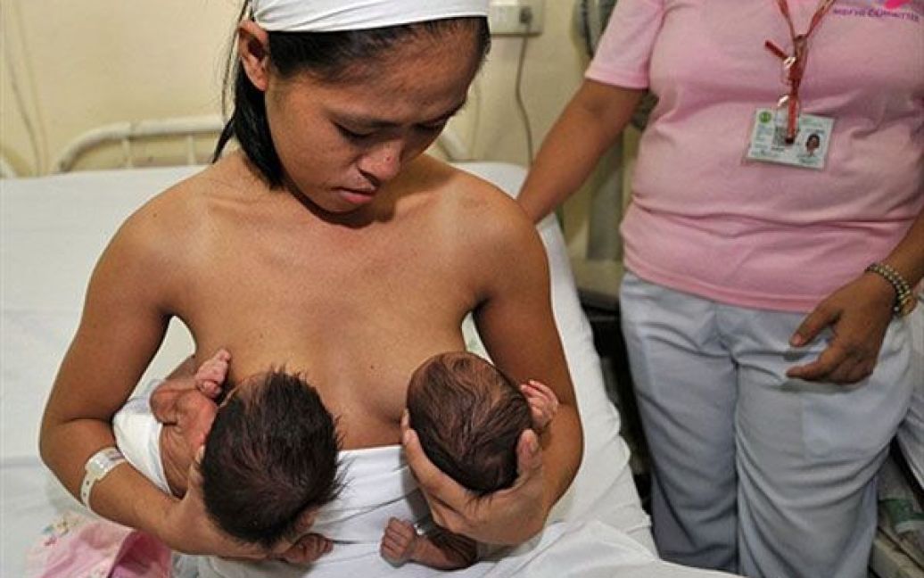 Філіппіни, Маніла. Мати годує грудьми новонароджених близнюків у державній лікарні Маніли. Кожен третій з немовлят на Філіппінах є небажаною або незапланованою дитиною. Країна бореться з проблемою демографічного вибуху і опозицією церкви у питанні контролю за народжуваністю. Населення Філіппін, за прогнозами, цього року досягне 94 млн, що більш ніж на 5 мільйонів перевищує показник перепису населення 2007 року. Впливова римсько-католицька церква, яка забороняє штучне обмеження народжуваності, активно і послідовно виступає проти програм контролю за чисельністю населення, а, отже, і уряд не хоче фінансувати розвиток планування сім&#039;ї у країні. / © AFP