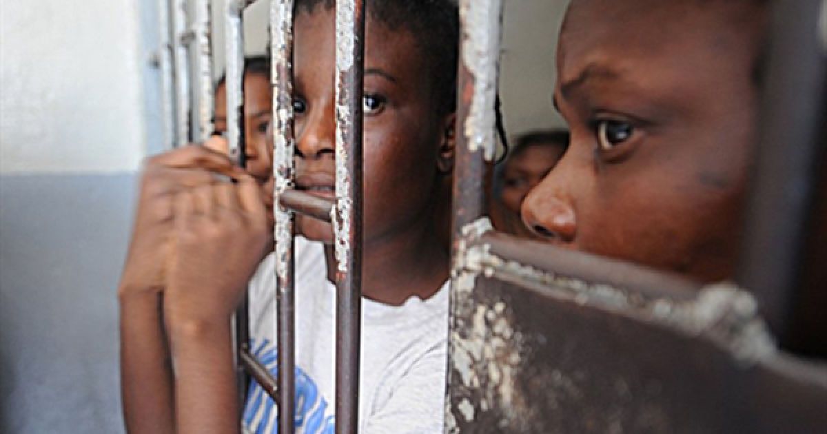 28.06. Жінки визирають зі своєї камери у тюрмі Порт-о-Пренса. В&rsquo;язниці Гаїті переповнені людьми, яким не винесено вироку, через зупинку у судочинстві, яка викликана страшним землетрусом 12 січня. / © AFP