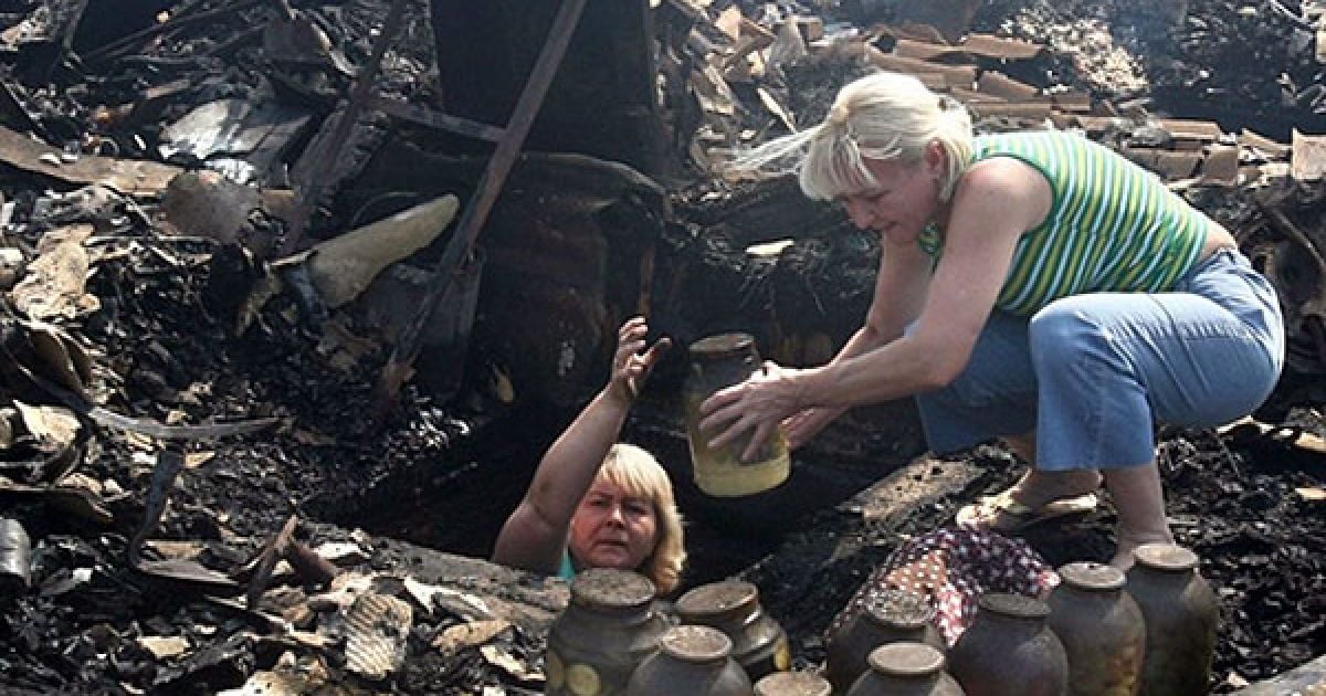 Росія, Остафьєво. Російські жінки рятують харчі з підвалу свого згорілого будинку у селі Остафьєво у 15 км від Москви. Президент Росії Дмитро Медведєв через швидке поширення лісових пожеж оголосив надзвичайний стан у 7 регіонах Росії. Цим указом також обмежено громадський доступ до постраждалих районів. / © AFP