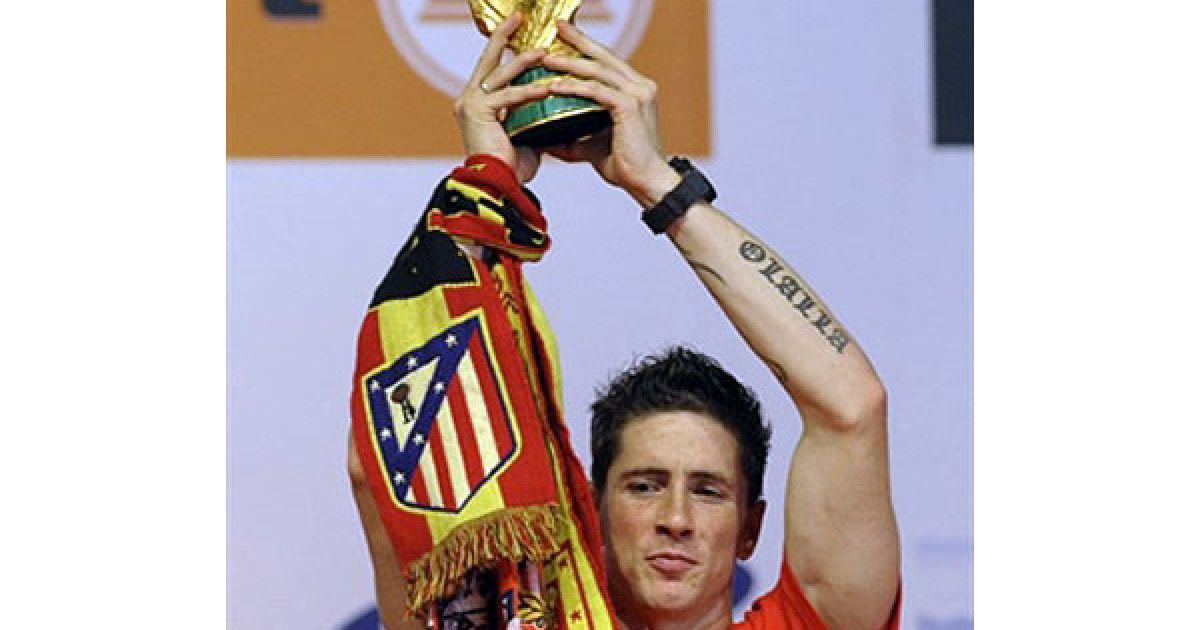 Нападаючий збірної Іспанії Фернандо Торрес тримає Кубок світу з футболу. / © AFP