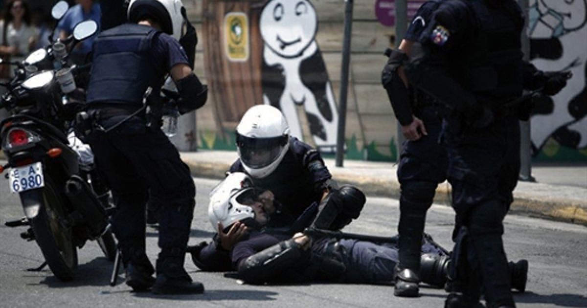 29.06. Поліцейський допомагає своєму колезі, який постраждав у сутичці з демонстрантами у центрі Афін. Грецію накрила друга хвиля страйків та демонстрацій проти урядової політики виходу з економічної кризи.