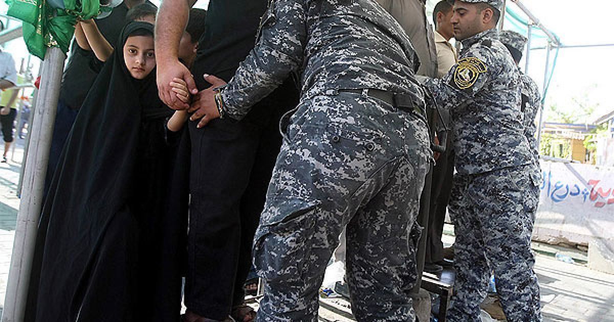 Ірак. Іракські поліцейські обшукують шиїтських паломників, які прийшли на службу до мечеті Мусса аль-Кадхім у Кадхимії. / © AFP