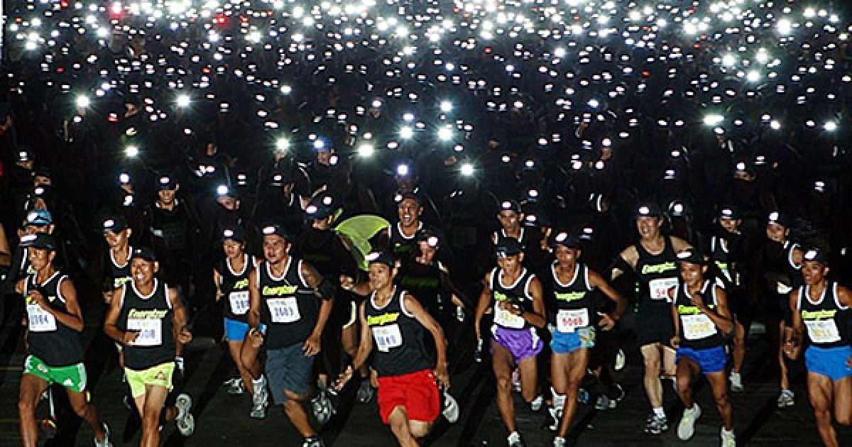 Філіппіни, Себу. Тисячі бігунів з ліхтариками беруть участь у нічному забігу "Energizer night race". Забіг відбувся у рамках благодійної акції "Біжи заради мети" на користь глухих дітей у провінції Себу. / © AFP
