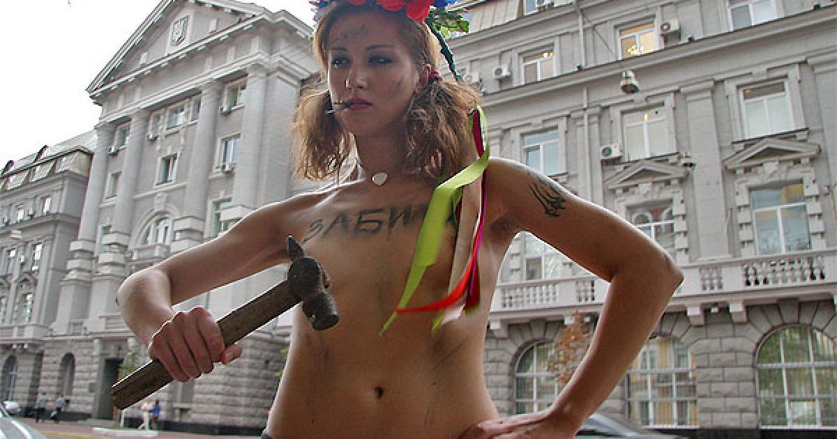 Активістка жіночого руху FEMEN з написом на грудях "Забили" вийшла до будівлі СБУ топлес, з молотком в руці та із цвяхами у роті. / © Жіночий рух FEMEN