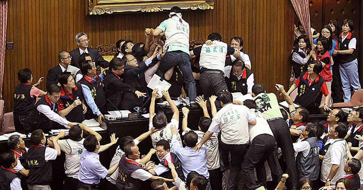 Тайвань, Тайбей. Депутаті від двох основних партій Тайваню б&rsquo;ються за електронний пристрій, який спікер парламенту використовує для підрахунку голосів, у парламенті в Тайбеї. Деякі тайваньські законодавці отримали поранення під час бійки, яка виникла протягом першого дня обговорення нової суперечливої торговельної угоди з Китаєм. / © AFP
