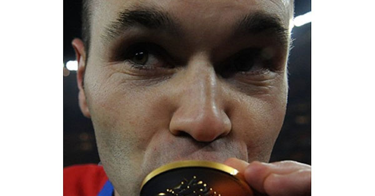 Андрес Іньєста цілує чемпіонську медаль... / © AFP