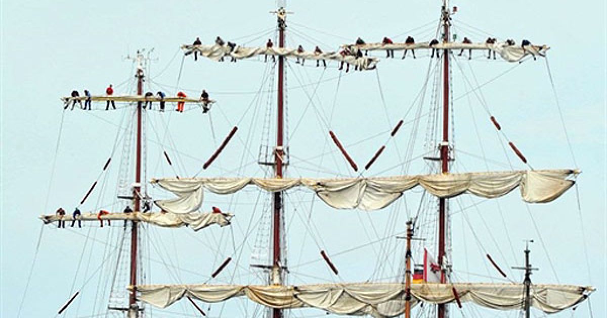 Німеччина. Чоловіки прибирають вітрила на парусному човні, який прокладає собі шлях через Балтійське море під час вітрильної регати Hanse Sail у Варнемюнде, на північному сході Німеччини. Організатори очікують, що регату відвідають до 1 млн глядачів. / © AFP