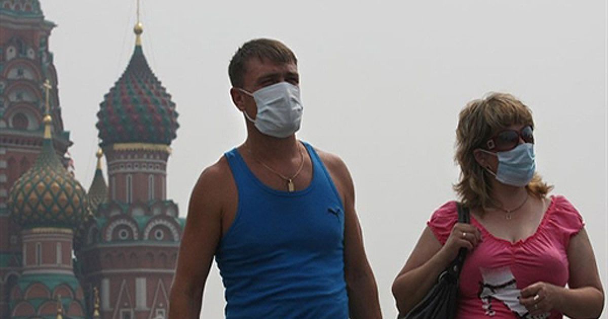 Туристи у захисних масках гуляють по Красній площі у Москві. Гості та жителі Москви змушені носити маски, щоб захиститися від смогу, який утворився внаслідок лісових пожеж. / © AFP