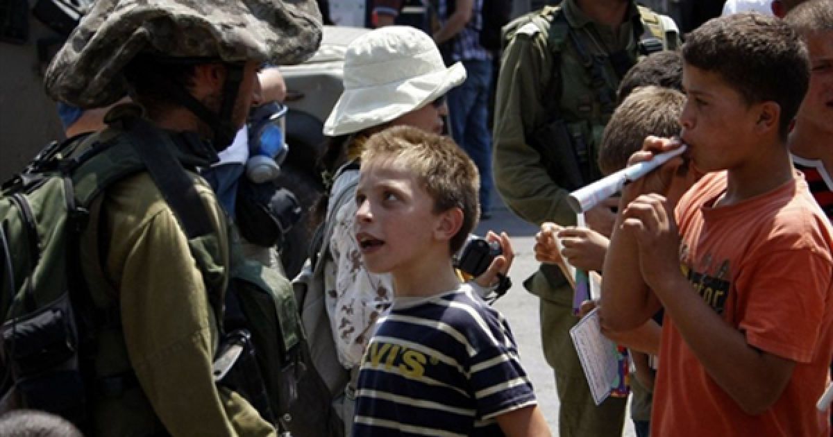 Палестинські хлопчики сперечаються із ізраїльськими солдатами під час щотижневої демонстрації проти окупації палестинських земель поблизу Раммали. / © AFP