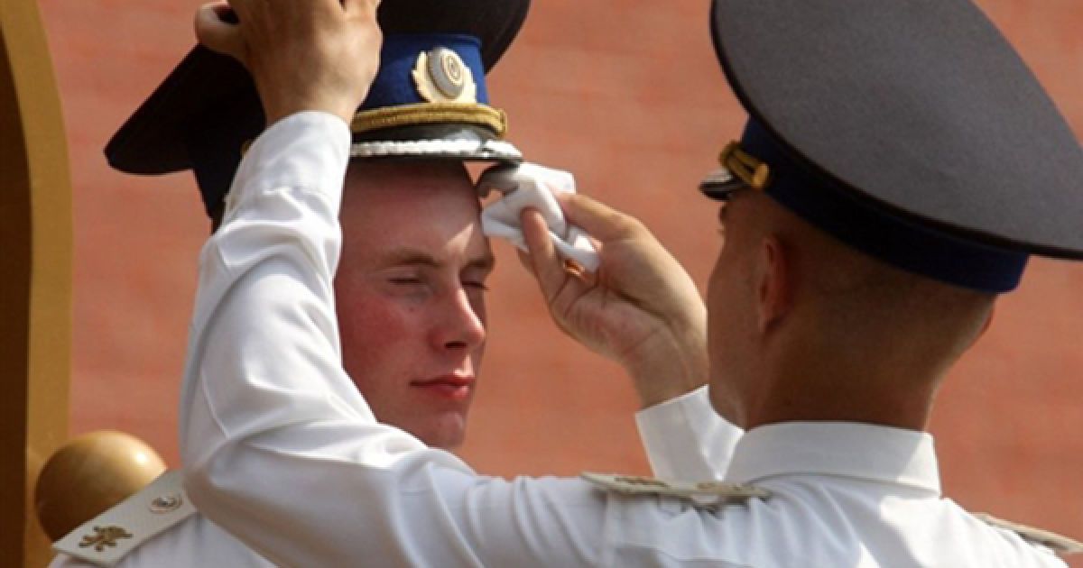 Солдат почесної варти у могили невідомому солдату витирає своєму напарникові піт з чола. Температура повітря у Москві тримається на позначці 25 градусів.