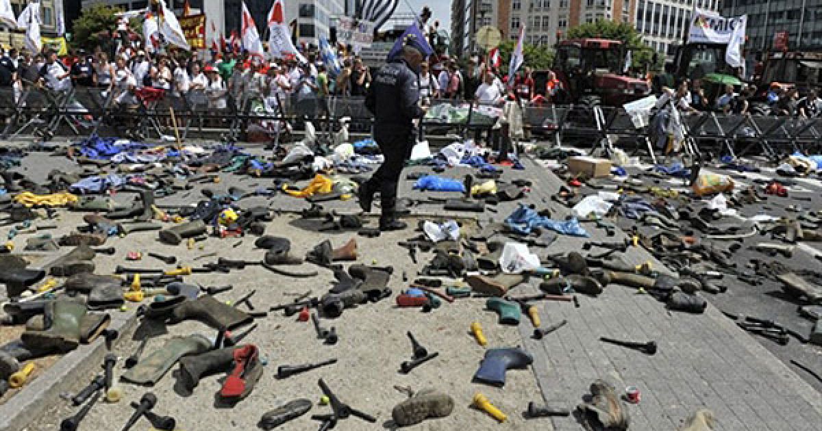 Бельгія, Брюссель. Поліцейський ходити серед чобіт і пластикових мішків, якими поліцію закидали виробники молока під час демонстрації у Брюсселі. Молочники-мітингувальники провели акцію протесту поруч із офісом ЄС під час засідання Ради з питань сільського господарства та рибальства у Брюсселі. Виробники молока зі всієї Європи виступили проти падіння цін на молоко і звернулися за допомогою до Брюсселя. / © AFP