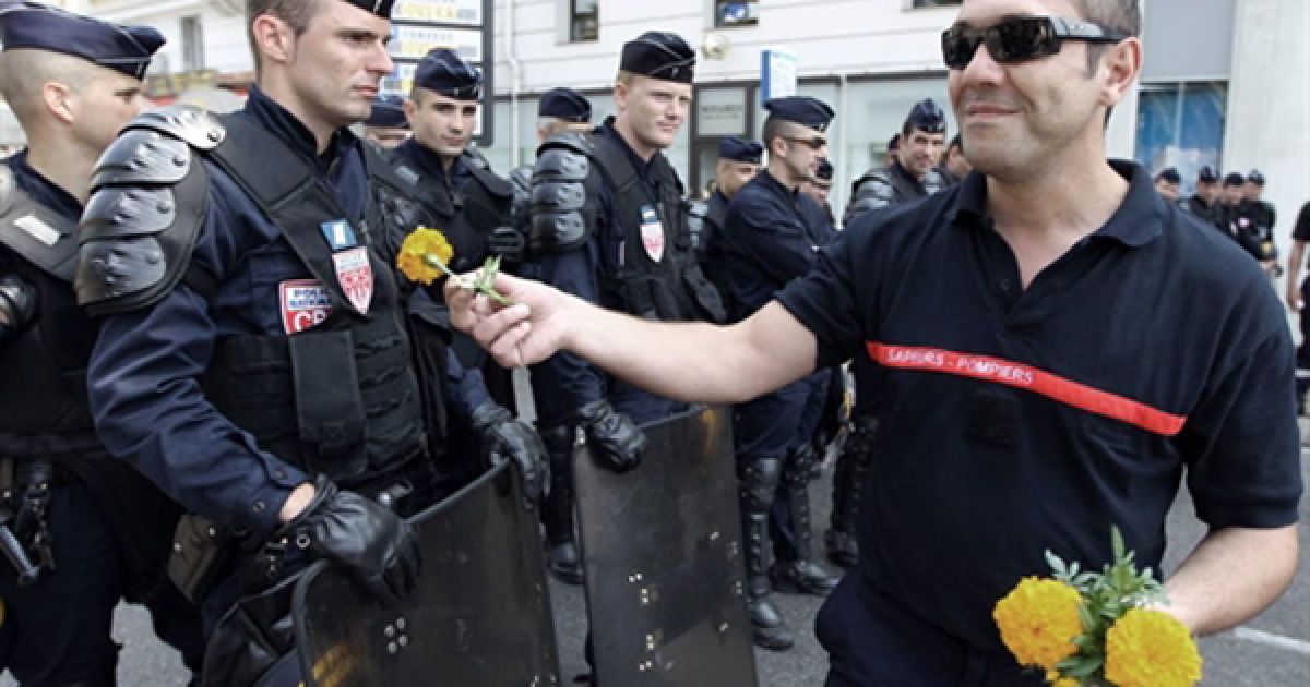 Пожежник дарує квіти поліцейським під акції протесту проти пенсійної реформи у Ніцці. Демонстрація закінчилася сутичкою пожежників та поліцейських, в наслідок якої 5 людей отримали поранення. / © AFP