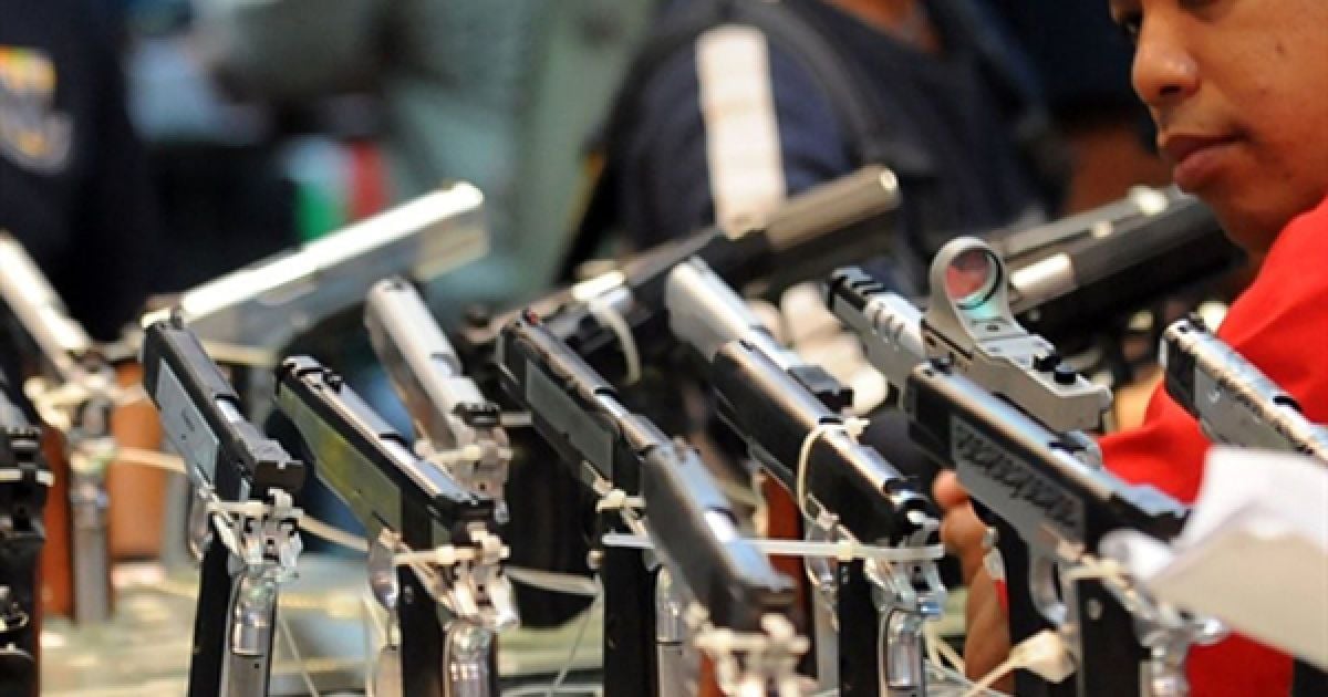 Чоловік розглядає пістолети 45-го калібру під час розпродажу конфіскованої зброї, який влаштувала філіппінська поліція. З 90 мільйонів людей населення Філіппін дозвіл на носіння зброї мають 1,8 мільйонів людей та ще 1,2 тримають її незаконно. / © AFP