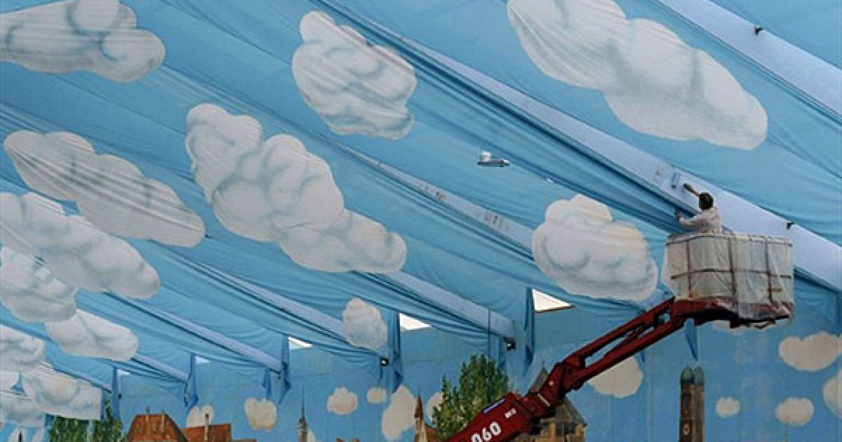 Німеччина, Мюнхен. Працівник розфарбовує дах величезного "пивного" намету під час підготовки до фестивалю пива "Октоберфест" у районі Терезіенвізе у Мюнхені. Найбільший у світі пивний фестиваль "Октоберфест" цього року відзначатиме своє 200-річчя і проходитиме з 18 вересня по 4 жовтня. / © AFP