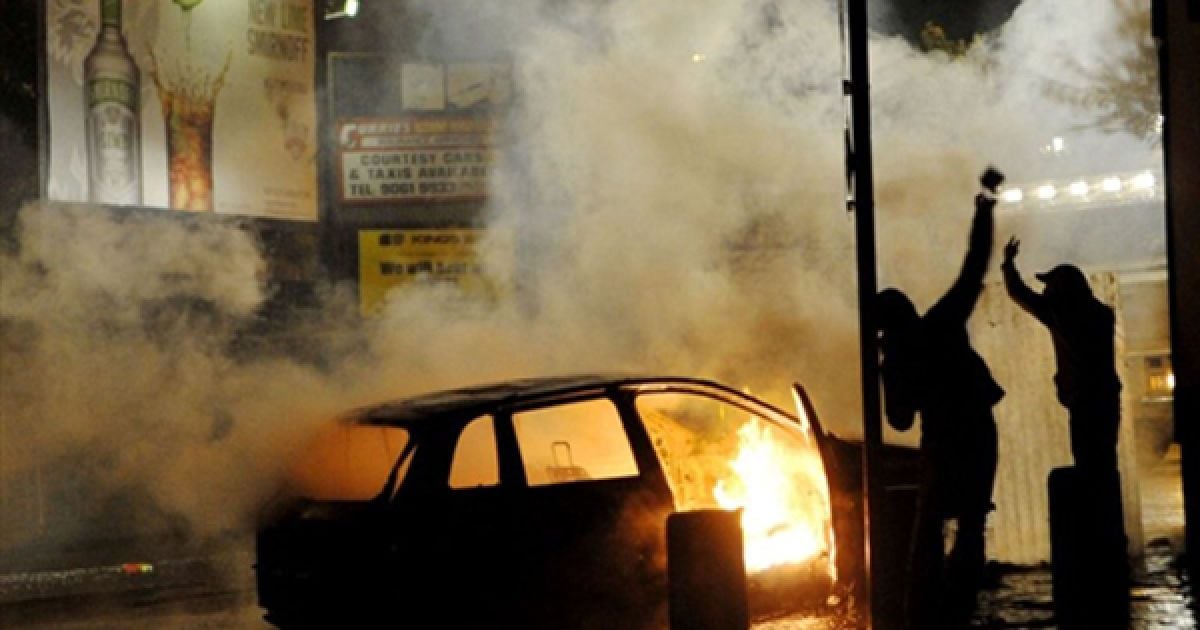 Демонстранти підпалили машину на одній з вулиці Белфасту. Заворушення націоналістів розпочалися у ніч перед парадом оранжистів, та тривають вже четвертий день. / © AFP