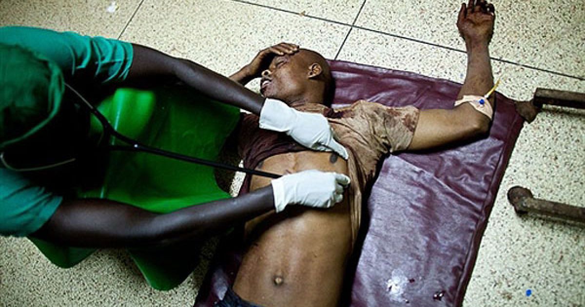 Уганда, Кампала. У лікарні Мулаго лікар надає допомогу пораненому. Під час показу фіналу Чемпіонату світу з футболу, в ресторані та спорт-барі столиці Уганди прогриміли два вибухи, в результаті яких загинули щонайменше 64 людини, десятки отримали поранення. Поліція стверджує, що вибухи у ресторані, який належить ефіопам, є терактом, який може бути пов'язані із погрозами "Аль-Каїди". / © AFP