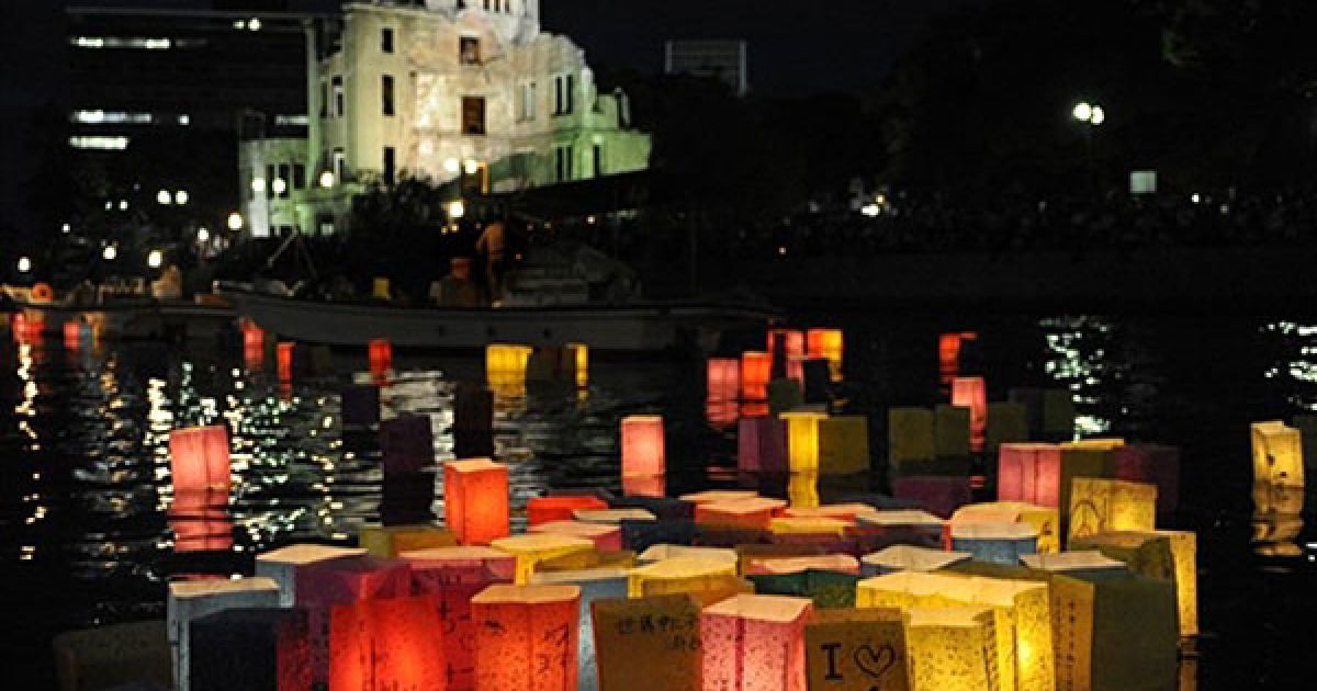 Японія, Хіросіма. Паперові ліхтарі зі свічками пливуть річкою Мотоясу поруч із будівлею Куполу атомної бомби у місті Хіросіма. Цього року виповнюється 65 років з моменту атомних бомбардувань японських міст Хіросіма і Нагасакі. У пам&rsquo;ятних заходах в Японії взяли участь представники понад 70 країн, у тому числі вперше до церемонії приєднався представник Сполучених Штатів. / © AFP