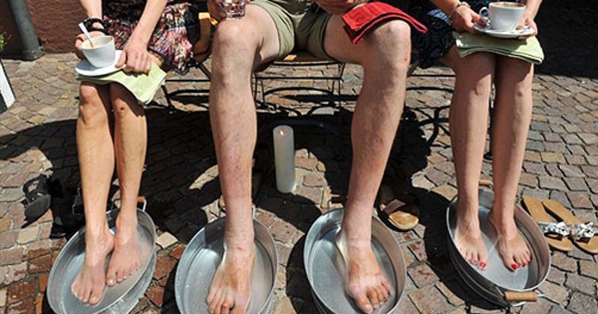 Німеччина, Вальдкірх. Відвідувачі кафе "In's Glueck" охолоджують ноги під час перерви на каву. У більшості країн Європи утримується спека. / © AFP