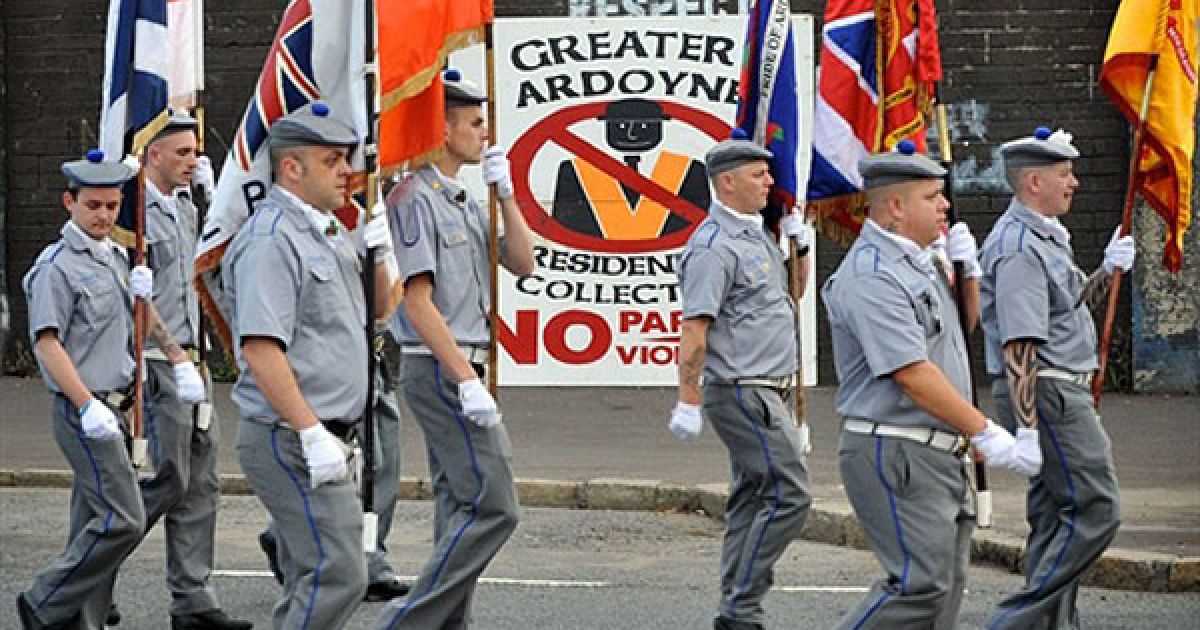 Великобританія, Белфаст. Учасники традиційного маршу протестантського Ордену оранжистів проходять повз націоналістичний район Ардойн у столиці Північної Ірландії. Під час підготовки до річниці битви на річці Бойн, на заході Белфаста спалахнули заворушення. Молоді католики-республіканці почали кидати пляшки із запальною сумішшю в представників поліції, намагаючись перешкодити проведенню традиційного параду протестантського Ордену оранжистів. В результаті заворушень постраждали 27 поліцейських. / © AFP