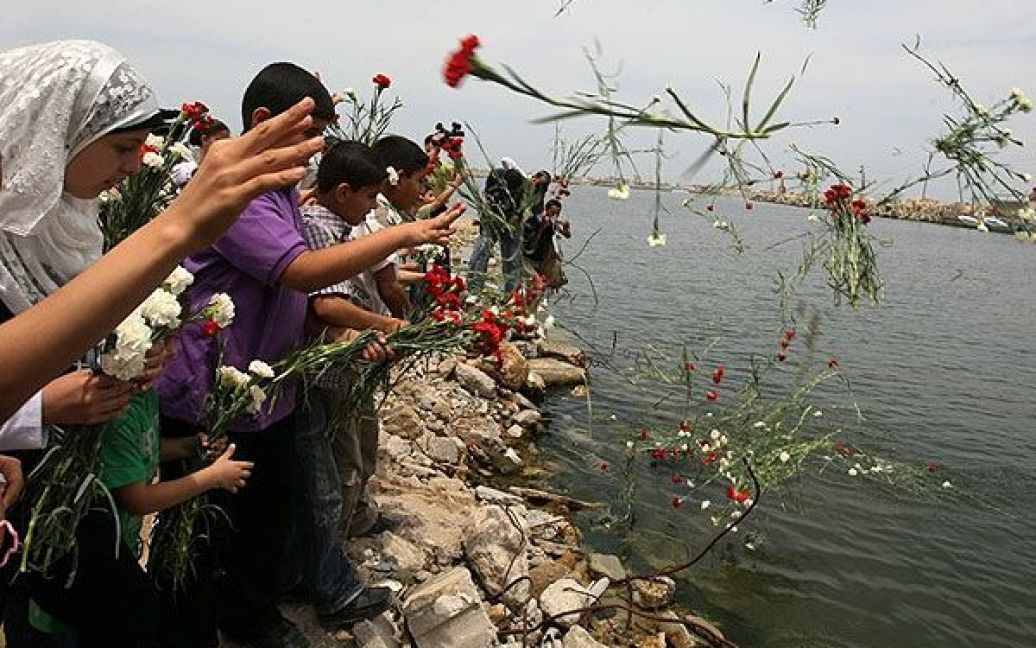 Сектор Газа. У місті Газа палестинські діти кидають квіти у море під час церемонії в пам&#039;ять про активістів, загиблих під час інциденту між ізраїльськім спецназом і "Флотилією свободи". / © AFP