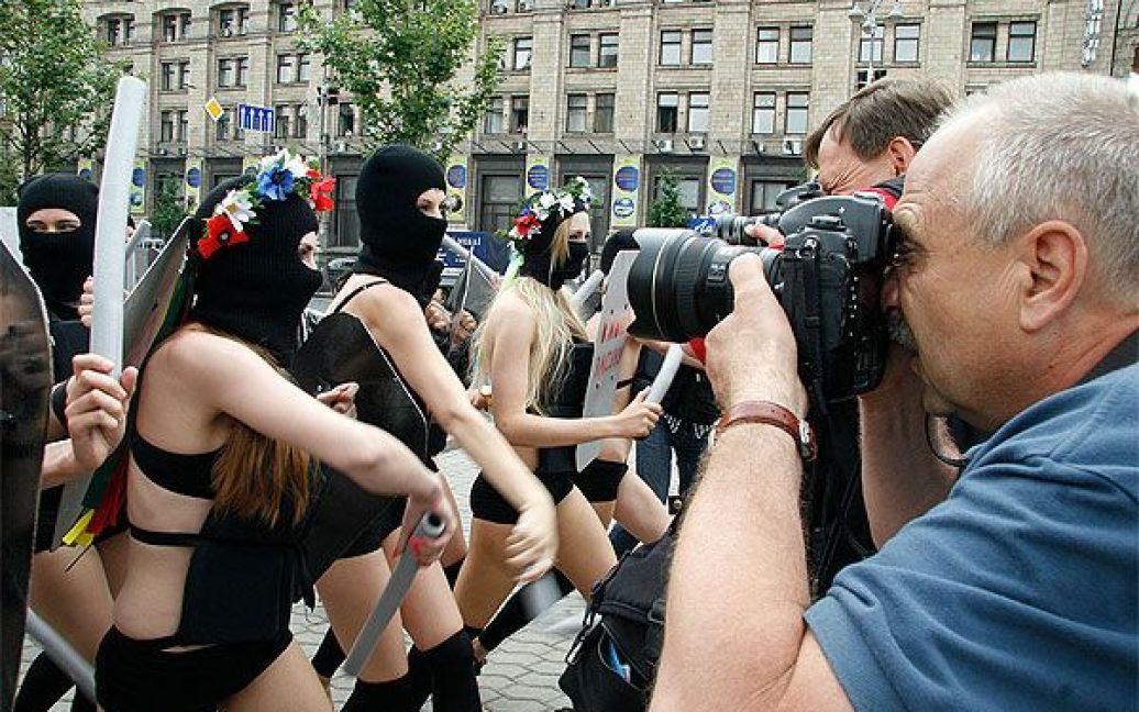 Активістки FEMEN вийшли на акцію у чорних костюмах, накшталт спецназівських, масках і з криками "Забери камеру!", "Не знімати, твою мать!" накинулися на журналістів і фотографів із поролоновими дубцями. / © Жіночий рух FEMEN