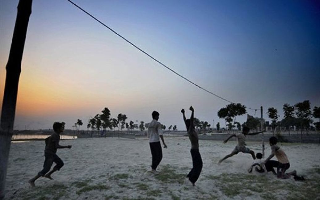 Дакка. Хлопчики грають у футбол на березі ріки Буріганги. Майже 40% населення Бангладеш живуть менше ніж на 1 долар на день. / © AFP