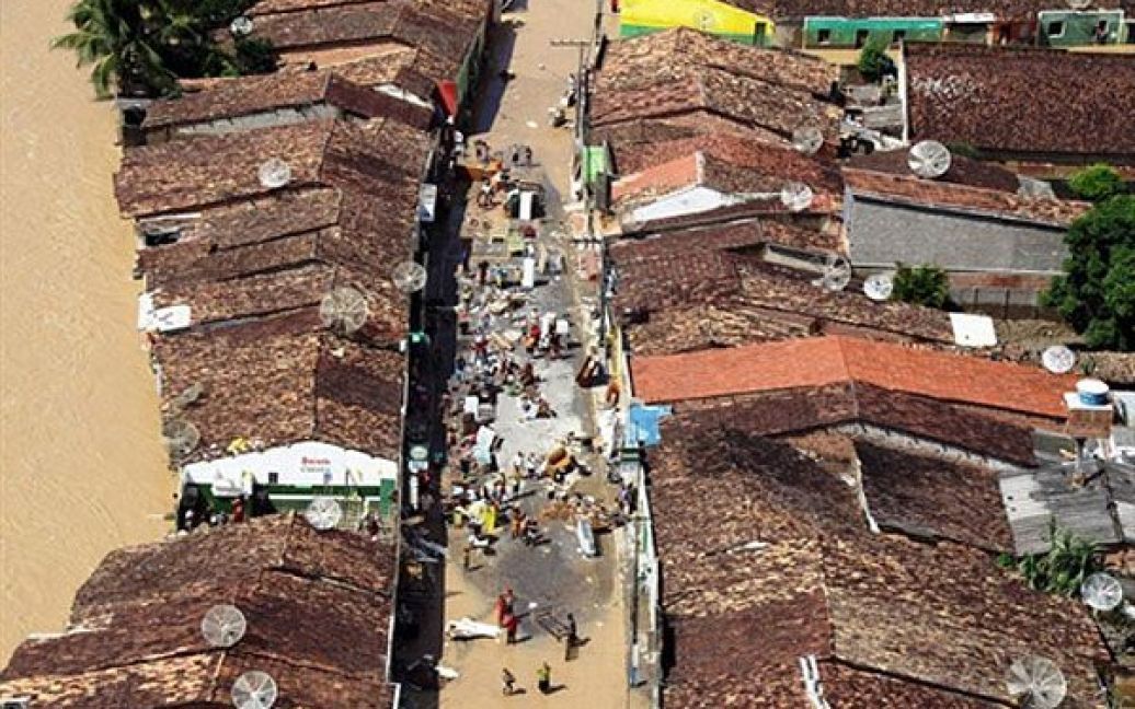 Бразилія, Хакуйпе. Місцеві мешканці намагаються врятувати свої речі з затоплених будинків у містечку Хайкупе, штат Алагоас. В результаті руйнівної повені на північному сході Бразилії у штаті Алагоас більше тисячі людей вважаються зниклими безвісти. Жертвами стихії вже стали 38 людей, десятки тисяч бразильців залишилися без даху над головою, було зруйновано безліч будинків, порушена транспортна система регіону. / © AFP