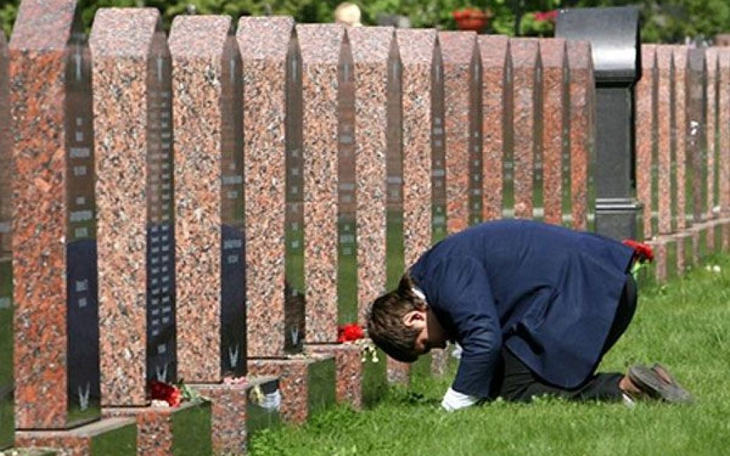 Росія, Москва. Чоловік стоїть на колінах перед могилами на військовому цвинтарі у Москві, де поховано багато учасників і ветеранів Великої Вітчизняної війни. / © AFP