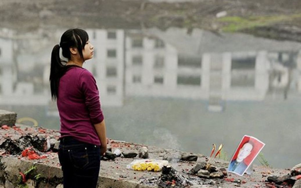 Жінка принесла квіти до місця, де знаходився її будинок, який було зруйновано під час землетрусу 2008 року. Сьогодні Китай вшанував 2-гу річницю землетрусу у провінції Сичуань, який забрав тисячі життів. / © AFP