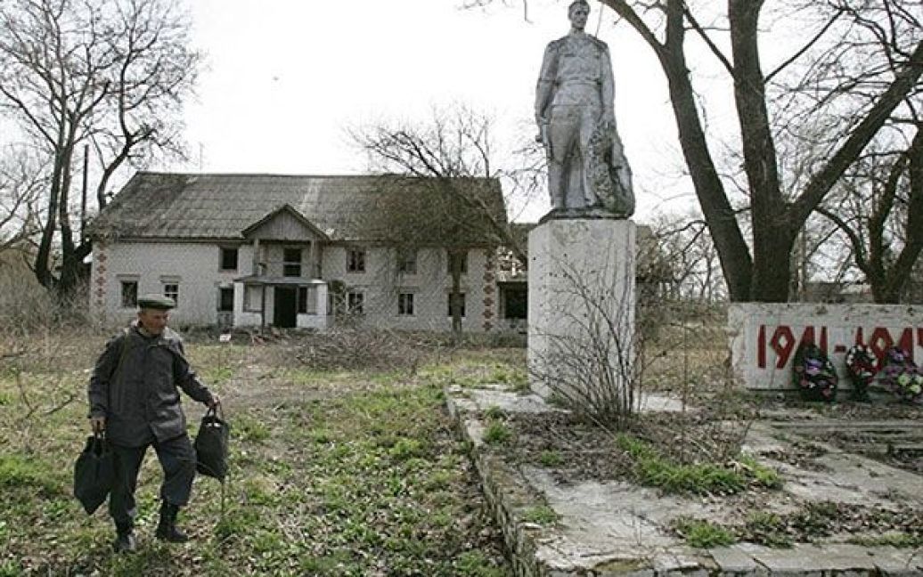 Білорусь, село Тулговичі, 30-км зона. Чоловік йде повз пам’ятник захисникам Вітчизни. / © AFP