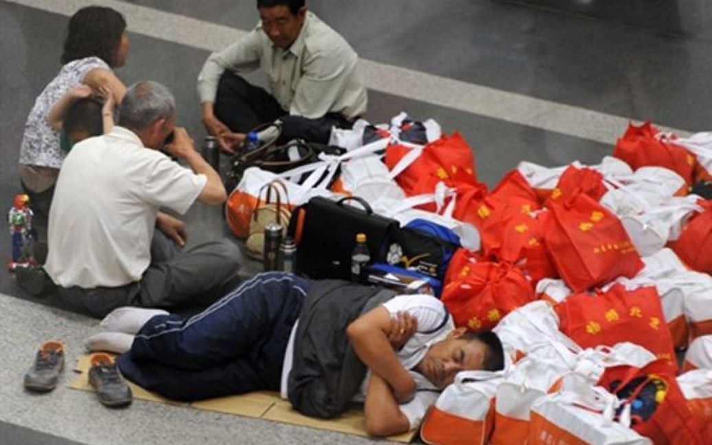 Пасажири сплять на підлозі аеропорту Пекіну. Через грозу довелося скасувати кілька сотень рейсів з Пекіну. / © AFP
