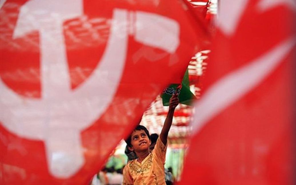 Дівчина тримає прапор Комуністичної партії під час мітингу лівих партій та організацій у Бангалорі. Ліві партії закликали своїх прихильників оголосити національний страйк доки парламент Індії не знизить ціни на товари першої необхідності. / © AFP