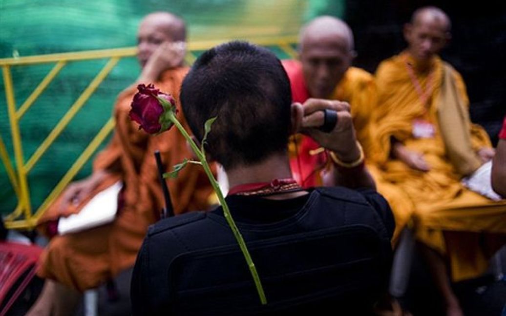 Чоловік розмовляє з буддистськими монахами у таборі "червоних сорочок" на окраїні Банкока. Опозиція погодилася із програмою чинного прем’єр-міністра Таїланду щодо виходу з політичної кризи, яка забрала життя 27 людей. / © AFP
