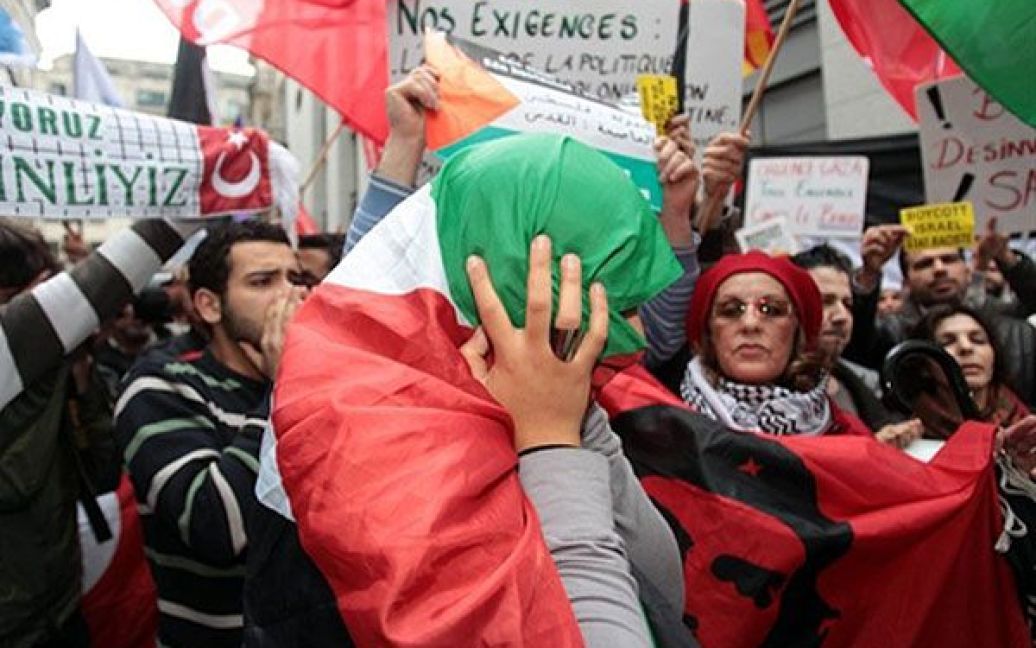 Бельгія, Брюссель. Демонстрант, загорнутий у палестинський прапор, під час антиізраїльської акції протесту. / © AFP